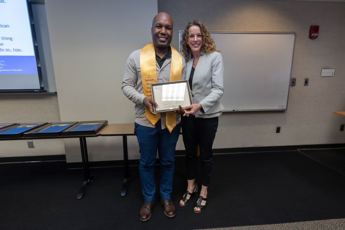 Student standing with Dr. Reneker with stole and certificate at the 2023 SOPH Research Day